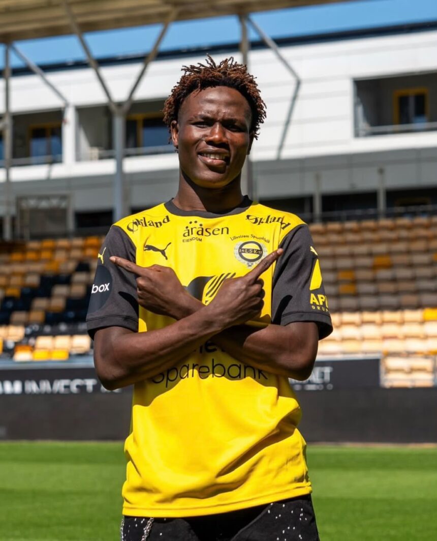 Soccer player in a yellow and black jersey crossing arms in a stadium looking at camera with a smile  trybalnews