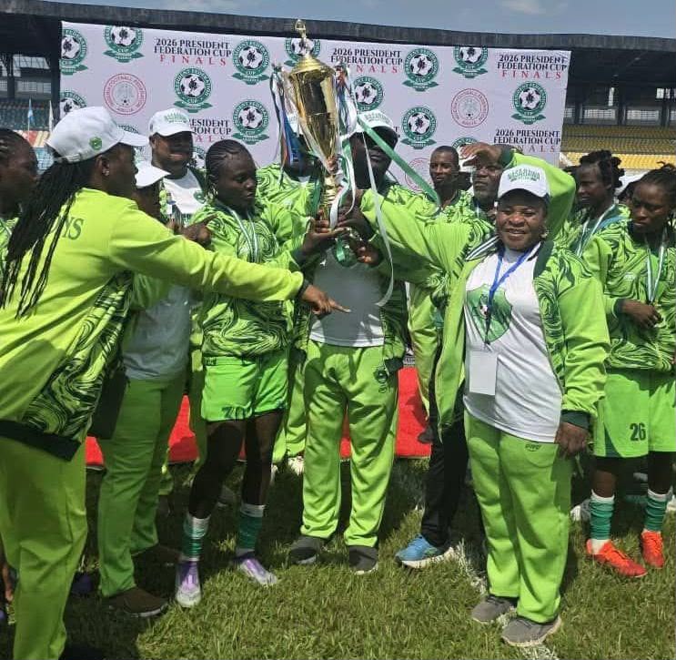 Women soccer team in neon green uniforms lifting a gold trophy on a grassy field  trybalnews