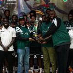 Group of Nigerian basketball players and staff posing with a trophy after a win ceremony  trybalnews