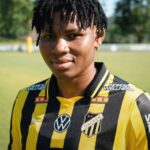 Portrait of a person with short dreadlocks wearing a black and yellow striped soccer jersey outdoors  trybalnews