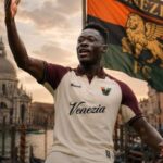Soccer player in a Venezia FC kit raises an arm in celebration with a flag behind him in a Venetian waterfront setting  trybalnews