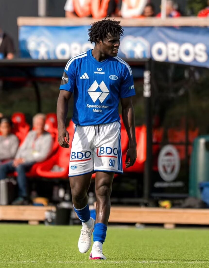 Male soccer player in blue jersey and white shorts walking on a green pitch during a game with spectators in the background  trybalnews