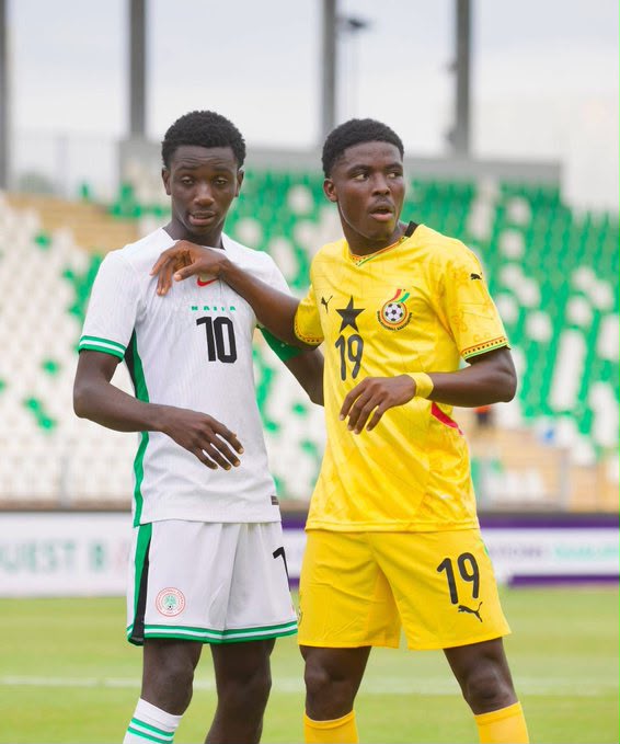 Two male soccer players on a field one in white with the number 10 and green trim the other in yellow with the number 19 standing close in a stadium  trybalnews