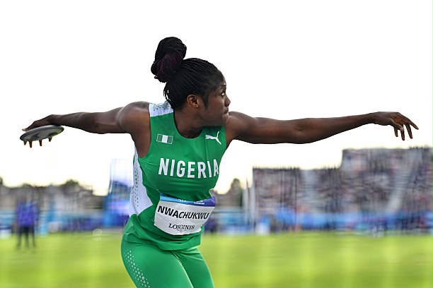 Female Nigerian track and field athlete in a green uniform throwing discus with arms extended mid throw on a field  trybalnews