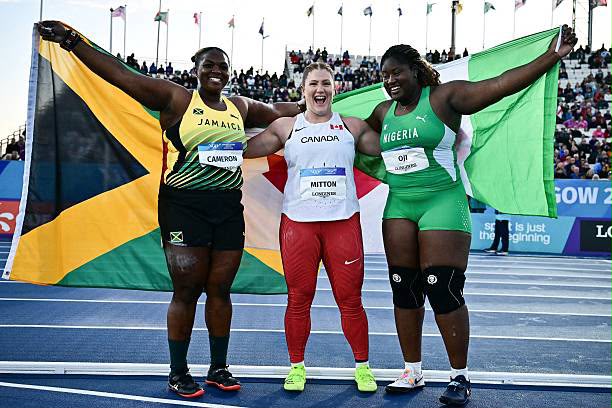 Glasgow 2026 Trybal News Three female sprinters stand arm in arm on a track smiling with Jamaica Canada and Nigeria flags behind them trybalnews
