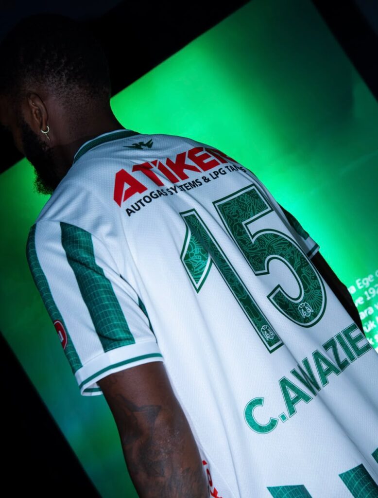 Chidozie Awaziem Trybal News Back view of a man in a white and green sports jersey number 15 with the name C Avazie on the back under green lighting trybalnews