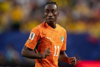 Soccer player in orange jersey with number 11 running on the field during a match.