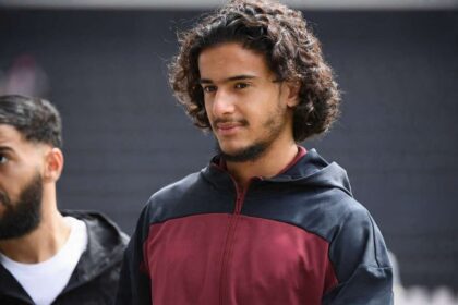 Ayyoub Bouaddi of Lille OSC walks with a maroon and navy training jacket featuring the New Balance logo and LOSC Lille crest ahead of the Ligue 1 McDonald's match between Angers and Lille at Stade Raymond Kopa on August 23, 2026 in Angers, France