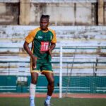 Male soccer player in green and orange kit performing an agility drill with orange cones on a training field  trybalnews