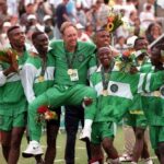 Nigerias head coach Johannes Bonfrere is chaired in the air by his players wearing green and white tracksuits after Nigeria beat Argentina 3 2 in the Football Final at the 1996 Olympic Games in Atlanta USA The gold medalists smile hold bouquets and wear gold medals around their necks while celebrating on the pitch with fans in the background  trybalnews