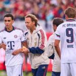 Bayern Munich midfielder Jamal Musiala wearing a white away kit is assisted off the pitch by FC Bayern team doctor Prof Dr Peter Ueblacker after falling during a preseason friendly between 1 FC Heidenheim and FC Bayern Munich at Voith Arena on August 18 2026 in Heidenheim Germany Harry Kane 9 is seen in the background  trybalnews