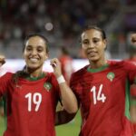Two female soccer players in red jerseys celebrate on the field fists raised in victory  trybalnews