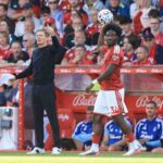 Nottingham Forest manager Oliver Glasner left in a black tracksuit gives instructions as player Ola Aina wearing a red home kit prepares to take a throw in during a Premier League match at the City Ground in Nottingham on Saturday August 22 2026  trybalnews