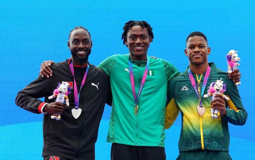 Gold medalist Samuel Ogazi of Team Nigeria in a green Puma tracksuit with the Nigerian flag stands in the center on the podium with his arm around silver medalist Jereem Richards of Trinidad and Tobago in a black jacket on the left and bronze medalist Zakithi Nene of South Africa in a green and yellow tracksuit on the right All three hold medals and Commonwealth Games mascots during the Mens 400 Metres Final medal ceremony on Day 9 of the Glasgow 2026 Commonwealth Games at Scotstoun Stadium August 1 2026  trybalnews