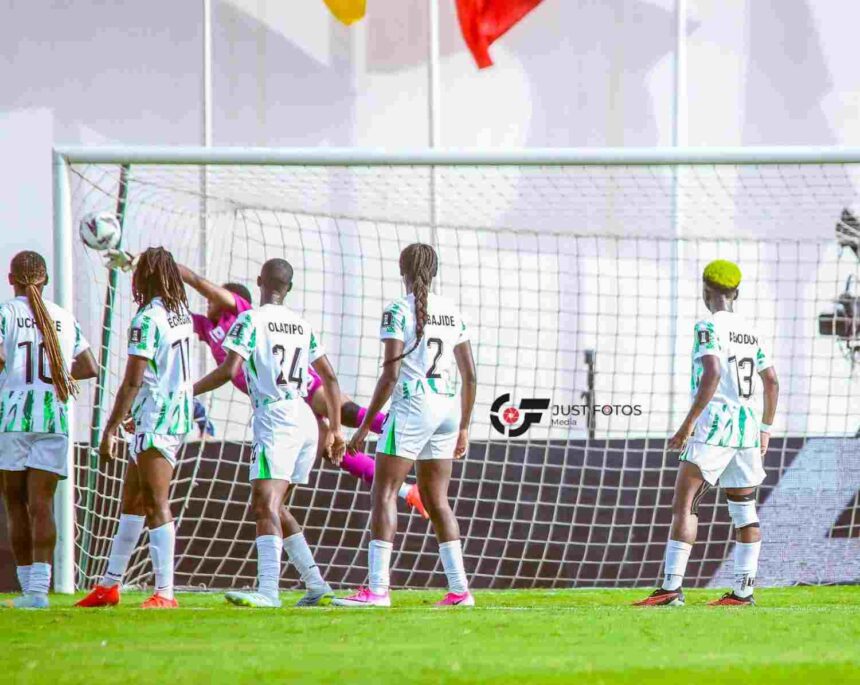 Womens soccer team in white and green uniforms gathers near the goal celebrating a moment near the net as the goalkeeper wears pink  trybalnews