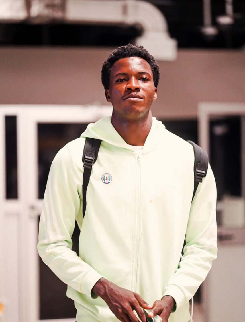 Portrait of a young man wearing a mint green hoodie with a backpack indoors looking at the camera  trybalnews
