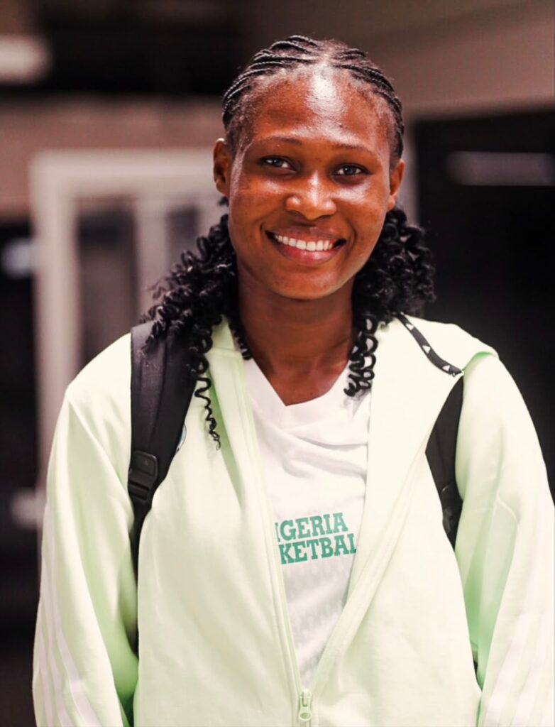 Smiling young woman with braided hair wearing a light green jacket and backpack looking at the camera  trybalnews