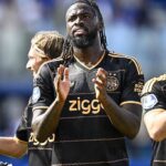 African soccer player in a black Ziggo jersey claps on the field during a match  trybalnews
