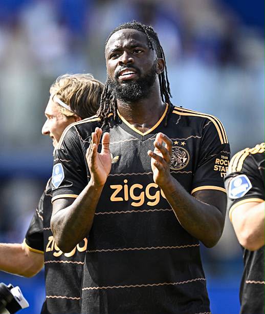 African soccer player in a black Ziggo jersey claps on the field during a match  trybalnews