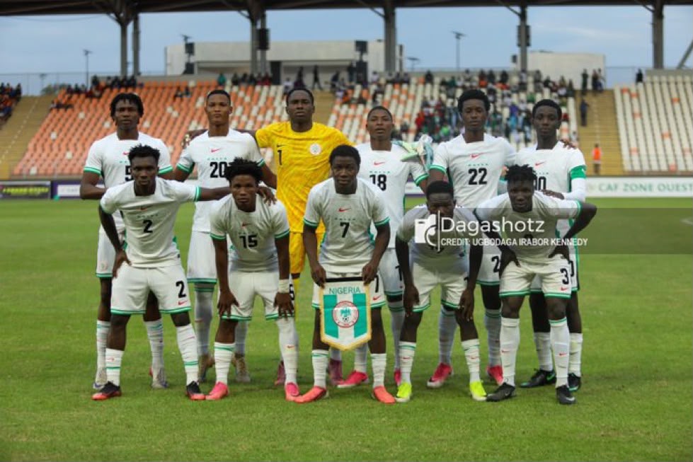 Nigeria mens national football team posing for a group photo on a soccer field white kits with green trim and a yellow clad goalkeeper in back row stadium in background  trybalnews