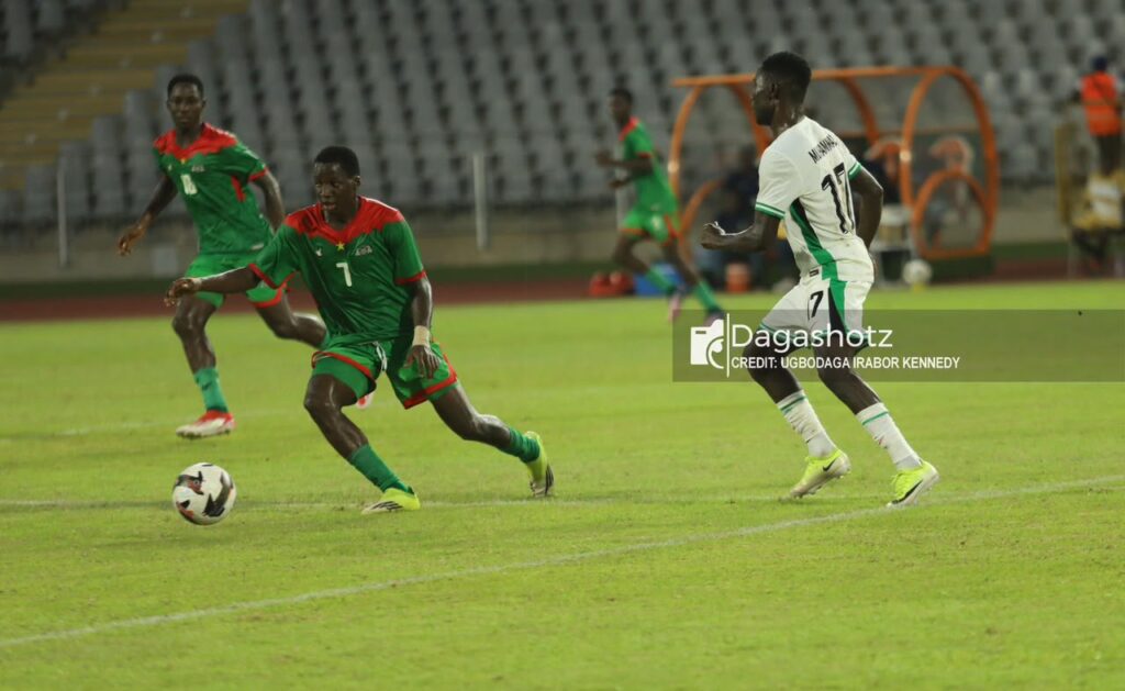 Soccer players in green and white chase the ball on a well lit grass field during a match  trybalnews