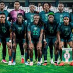 Nigeria womens national football team group photo on the pitch in teal kits with a Nigeria banner visible in front  trybalnews