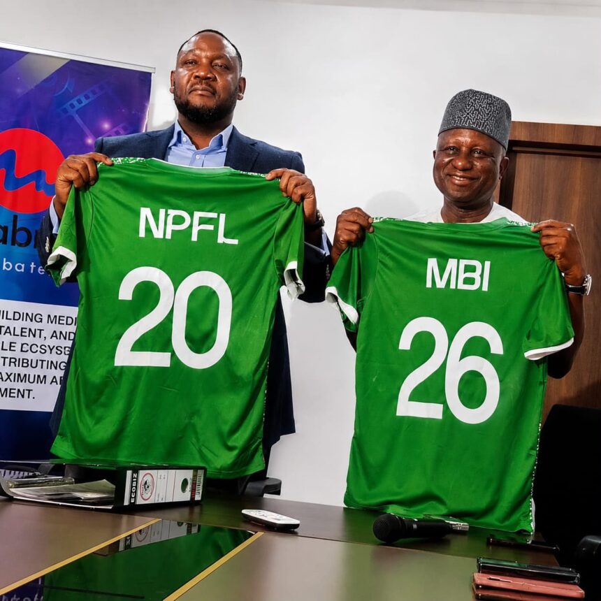 Two men hold up green sports jerseys with numbers 20 and 26 symbolizing team players during a signingpress event  trybalnews