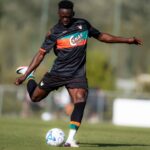 Soccer player in a black kit kicks a ball on a sunny training field  trybalnews