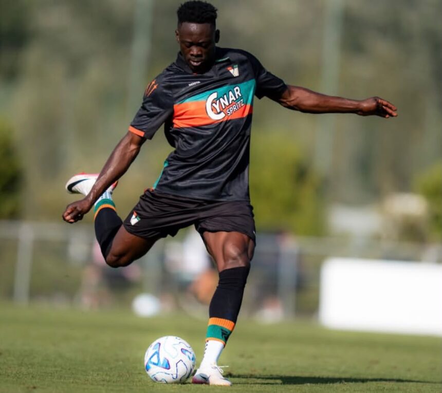Soccer player in a black kit kicks a ball on a sunny training field  trybalnews