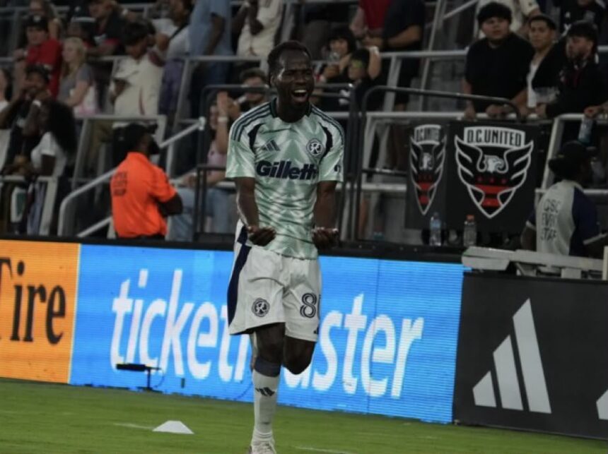 Soccer player in a mint green jersey number 88 celebrating on the field with fans in the stands behind him  trybalnews