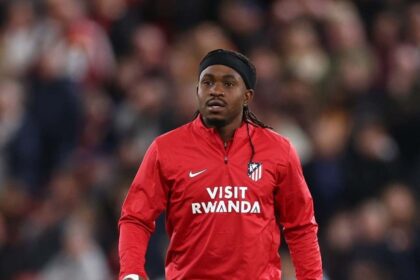 Ademola Lookman of Atletico de Madrid wearing a red and white striped jersey and blue shorts warms up during half time on the pitch at Anfield during the UEFA Champions League 2026/27 League Phase match between Liverpool FC and Atletico de Madrid on September 9, 2026 in Liverpool, England.