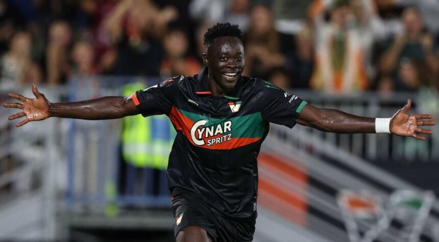 Akor Adams of Venezia FC in a black green and orange jersey with number 4 celebrates with arms outstretched after scoring the opening goal during the Serie A match between Venezia and ACF Fiorentina at Stadio Pier Luigi Penzo on September 11 2026 in Venice Italy  trybalnews