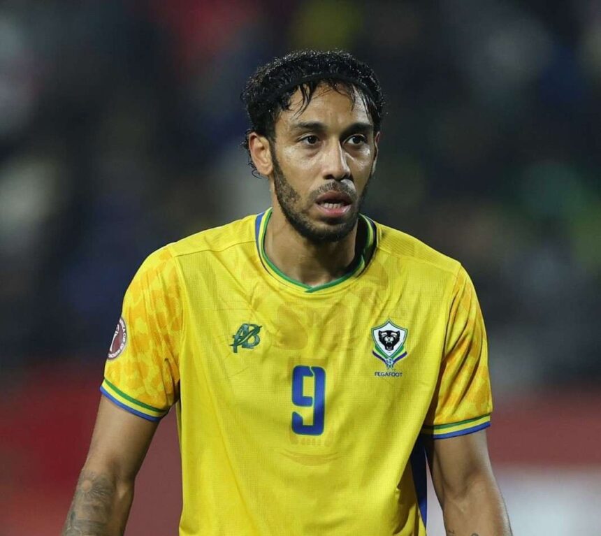 Gabon forward Pierre Emerick Aubameyang reacts during the Africa Cup of Nations Group F match between Cameroon and Gabon at Adrar Stadium in Agadir on December 24 2025 The striker wears Gabons yellow home jersey with blue number 9 and the FEGAFOOT crest with a blurred stadium crowd in the background  trybalnews