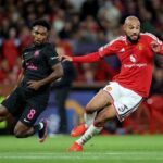 Christian Nwachukwu of Sabah FC in a black jersey with pink number 8 challenges Noussair Mazraoui of Manchester United in a red home kit during the UEFA Champions League 202627 League Phase match at Old Trafford on September 10 2026 in Manchester England  trybalnews