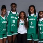 Nigerias womens national basketball team DTigress pose together in green home jerseys with NIGERIA and XE Jet on the front Players wear jersey numbers 1 32 5 and 6 and stand on either side of Head Coach Rena Wakama who is in a white Nigeria polo and black pants The team smiles in front of a plain grey backdrop  trybalnews