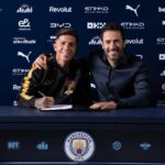 Enzo Fernandez signs his contract as a new Manchester City player at a signing table wearing a black and gold training top He is seated next to a Manchester City official with an arm around his shoulder The backdrop features Manchester City and sponsor logos including Etihad Puma and Betway  trybalnews