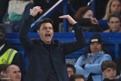 Mauricio Pochettino in a dark coat and black shirt gestures with both hands raised on the touchline during the English Premier League match between Chelsea and Tottenham Hotspur at Stamford Bridge in London on May 2, 2024.