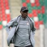 Moses Aduku Head Coach of Nigeria stands on the pitch wearing a grey Nigeria tracksuit and black cap before the FIFA U 20 Womens World Cup Group F match between Spain and Nigeria at Arena Sosnowiec in Sosnowiec Poland on September 7 2026  trybalnews