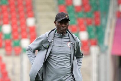 Moses Aduku, Head Coach of Nigeria, stands on the pitch wearing a grey Nigeria tracksuit and black cap before the FIFA U-20 Women’s World Cup Group F match between Spain and Nigeria at Arena Sosnowiec in Sosnowiec, Poland on September 7, 2026.