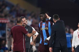 Trabzonspor striker Paul Onuachu wearing a maroon and light blue jersey with number 30 walks off the pitch injured surrounded by coaching staff during the Turkish Süper Lig week 4 match between Trabzonspor and Gençlerbirliği at Papara Park in Trabzon Türkiye on September 6 2026  trybalnews