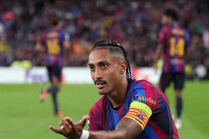 Raphinha of FC Barcelona wearing the captain's armband crouches on the pitch and gestures with his hands after scoring during the UEFA Champions League 2026/27 League Phase match between FC Barcelona and Feyenoord at Camp Nou in Barcelona, Spain on September 9, 2026.