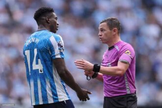 Referee Tony Harrington speaking with Coventry City forward Taiwo Awoniyi wearing number 14 during the Premier League match between Coventry City and Brighton & Hove Albion at The Coventry Building Society Arena on September 13, 2026