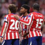 Ademola Lookman of Atletico Madrid wearing a black headband and red and white striped Atletico jersey celebrates with teammates Giuliano Simeone number 20 and Jonathan David number 15 after scoring his teams second goal during the UEFA Champions League 202627 League Phase MD2 match between Atletico de Madrid and Manchester United at Estadio Metropolitano on October 13 2026 in Madrid Spain  trybalnews