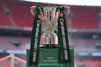 Silver Carabao Cup trophy with green Carabao Energy Drink ribbons on green plinth reading Arsenal v Manchester City Final 2026  trybalnews