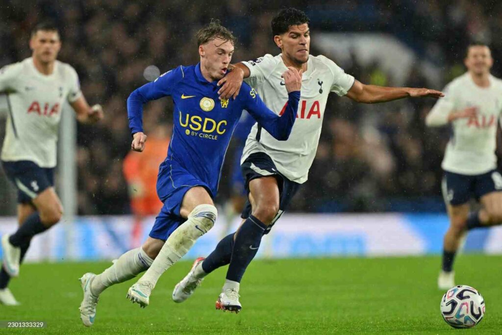 Chelsea player Cole Palmer in blue USDC kit being challenged by Tottenham Hotspur player in white AIA kit during Premier League match at Stamford Bridge ball in foreground  trybalnews