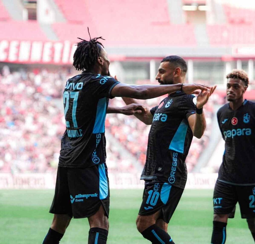 Chibuike Nwaiwu wearing Trabzonsporaposs black and blue away kit with number 27 celebrates with teammate number 10 after scoring Trabzonsporaposs second goal against Samsunspor in the Turkish Super Lig  trybalnews