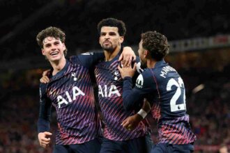 Tottenham Hotspur's Dominic Solanke celebrates scoring with teammates Archie Gray and Omar Marmoush during a Premier League match at Old Trafford.