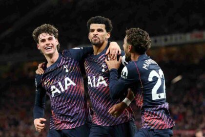 Tottenham Hotspur's Dominic Solanke celebrates scoring with teammates Archie Gray and Omar Marmoush during a Premier League match at Old Trafford.
