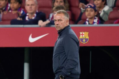 FC Barcelona manager Hansi Flick wearing dark blue tracksuit standing on touchline with hands in pockets during LaLiga match vs Real Madrid at Camp Nou