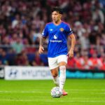 Lisandro Martinez of Manchester United, wearing the blue away kit with Snapdragon sponsor and white shorts, controls the UEFA Champions League ball on the pitch during the UEFA Champions League 2026/27 League Phase MD2 match between Atletico de Madrid and Manchester United at Estadio Metropolitano on October 13, 2026, in Madrid, Spain.